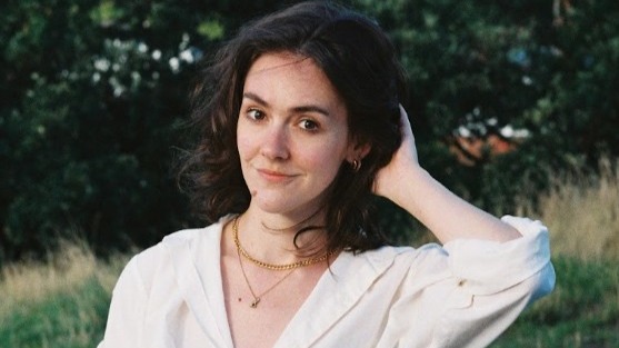 Julia Armfield, a young white woman with long dark hair and a white top